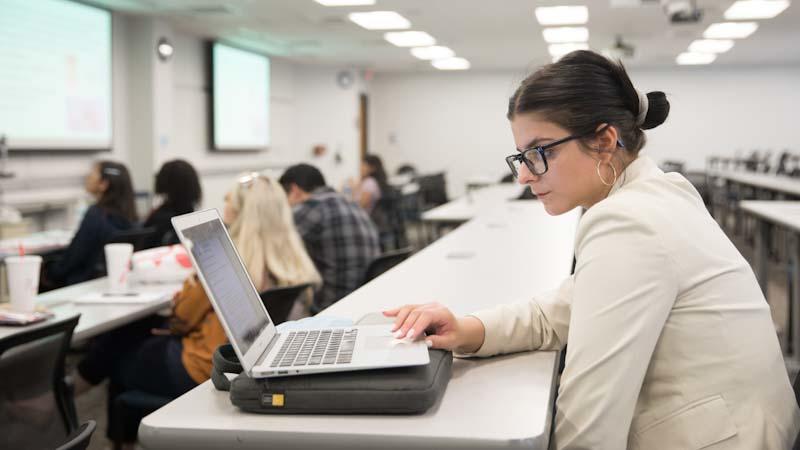 Student in classroom with a laptop