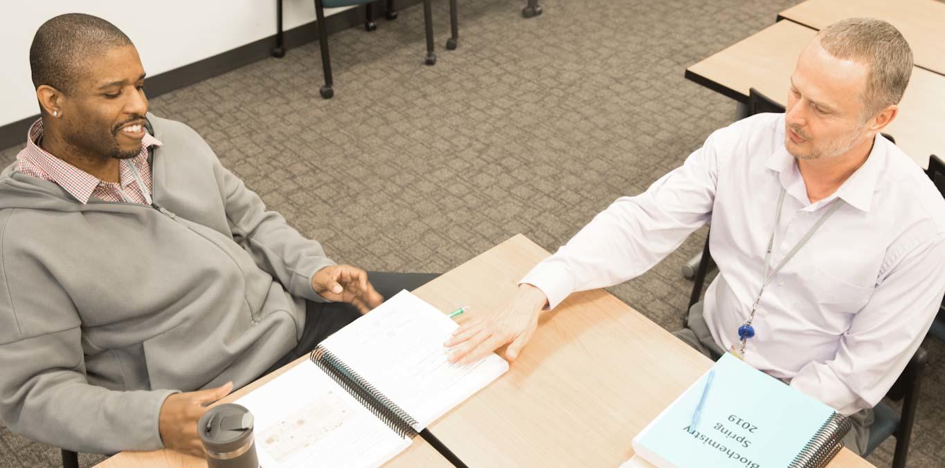 Teacher with a student at desks